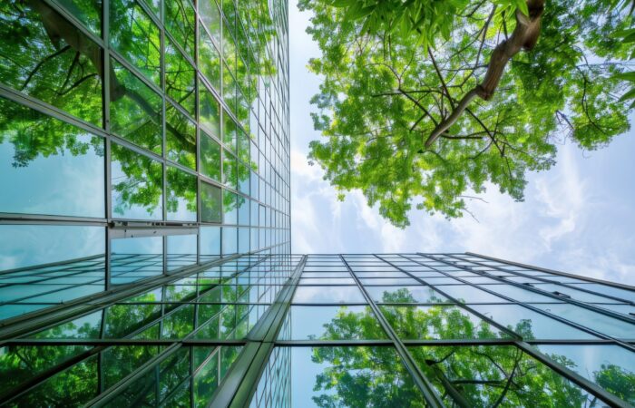 Modern green glass building with reflection of trees, ecofriendly architecture concept, building facade view from below, green energy and environment friendly idea stock photo, high resolution in the style of contest winner. --ar 16:9 Job ID: 4b44c8e4-805c-4196-bbd8-e7ffd4476820